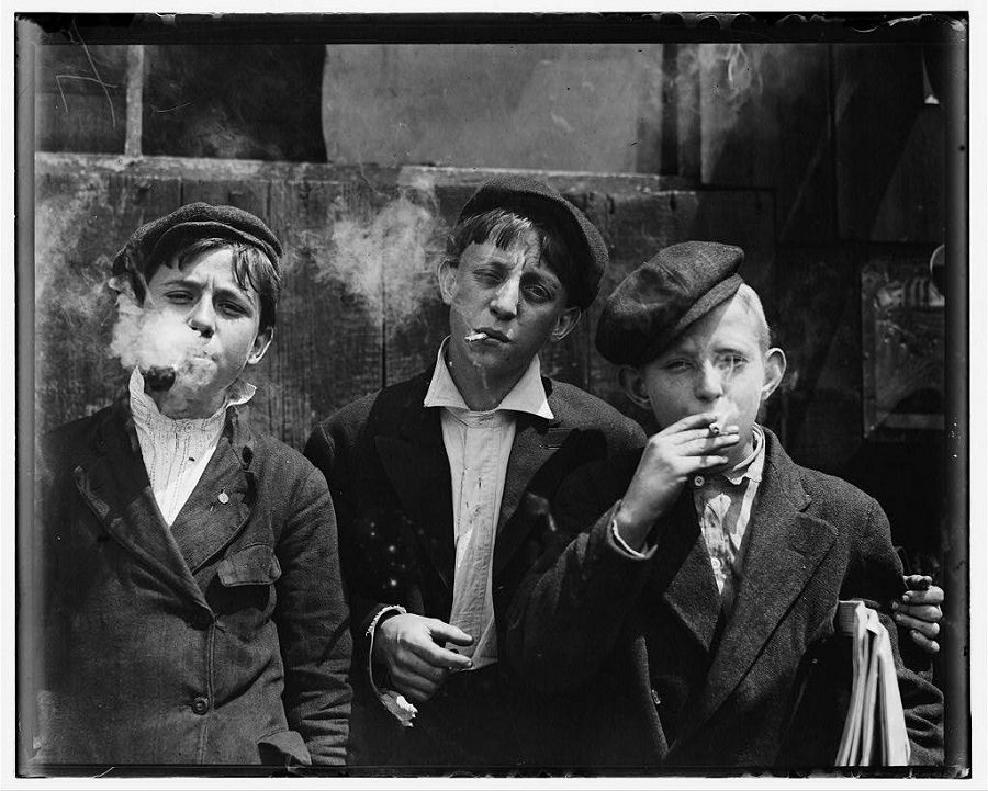Мальчишки разносчики газет во время небольшого перекура. Да, все они курят. Сент-Луис, Миссури. 1910 год