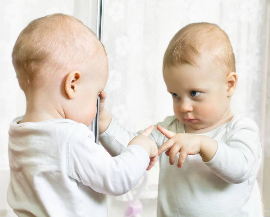 ребенок смотрит в зеркало